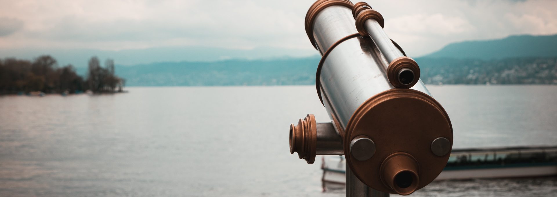 brown and silver telescope near body of water during daytime